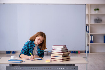 Young female student preparing for exams in the classroom