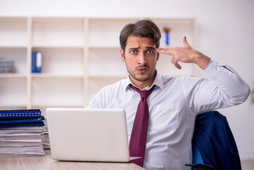 Young male employee and too much work in the office