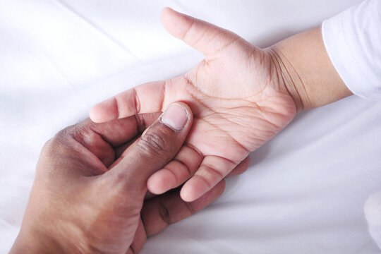 Father Holding Hand Of Baby Child, Close Up .