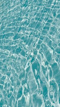 Aqua waves rippling through pool on sunny day