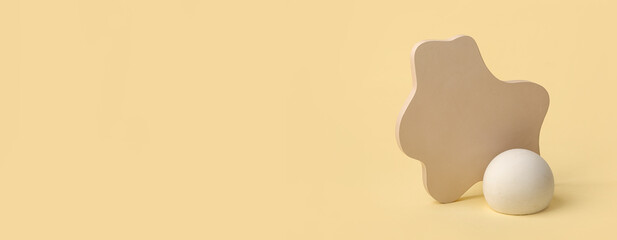 Empty modern podiums on light yellow background with space for text © Pixel-Shot