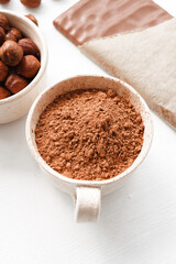 Bowl with cocao, chocolate and nuts, close up