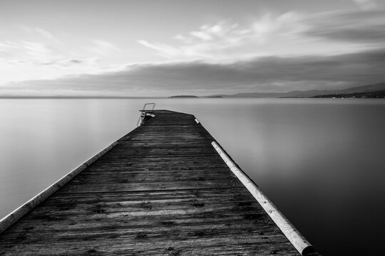 Long exposure view of a pier on a lake with perfectly still water