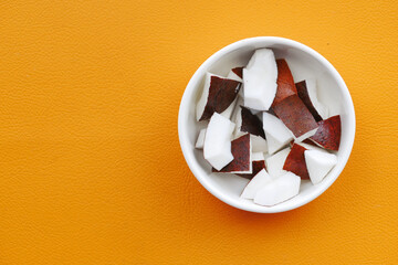 slice of fresh coconut on orange background 