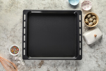 Baking tray with ingredients and utensils on grunge background
