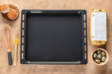 Baking tray with muffins, eggs and utensils on grunge background