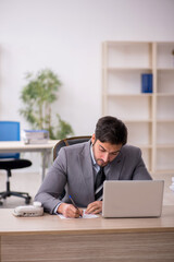 Young male employee and too much work in the office