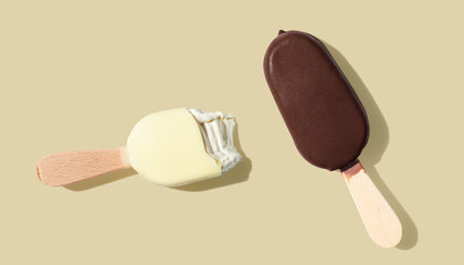 Chocolate and vanilla ice cream on a stick on yellow pastel background - obrazy, fototapety, plakaty