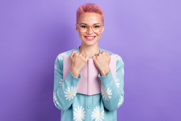 Portrait of adorable pretty cheerful lovely girl with pink hairdo wear blue pullover hugging book isolated on violet color background