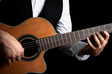 Hombre elegante vestido con chaleco y camisa, tocando la guitarra clásica - obrazy, fototapety, plakaty