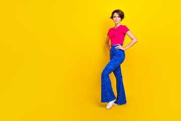 Fototapeta na wymiar Photo of lovely pretty lady wear bright pink clothes stand near empty space promotes new collection isolated on yellow color background