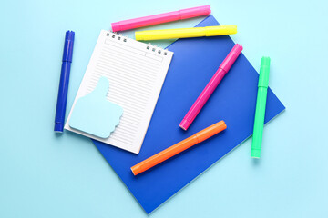 Fototapeta na wymiar Notebooks, sticky notes and felt-tip pens on color background