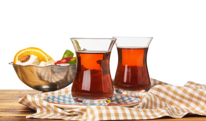 Glass cups of Turkish tea on wooden table against white background