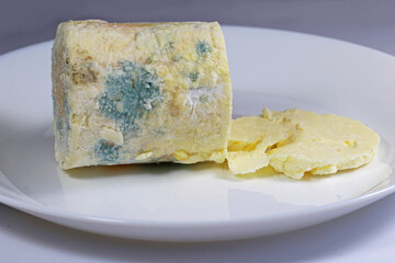 Round sliced blue cheese on a white plate