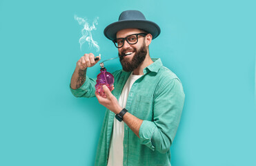 Funny rastaman hipster guy smokes marijuana through a bong and blows smoke.