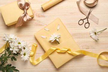 Composition with gift boxes, ribbon, scissors and flowers on wooden background. Women's Day celebration
