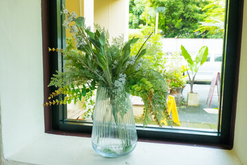 Beautiful Flower in vase with window in room.
