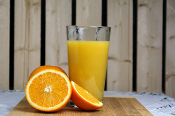 Glass of oragne juice on wood — clouseup