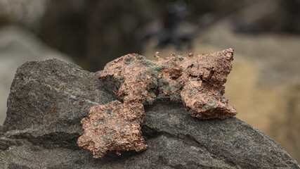 raw copper ore resting on a rock
