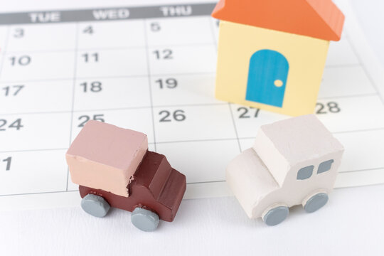 カレンダーと玩具の家と自動車。引っ越し予定のイメージ 