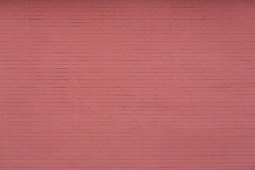 Red brick wall texture. Decorative plaster imitating brickwork. Background with plastered and painted wall.
