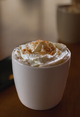 Coffee caramel latte white mug on the table. Morning coffee for breakfast