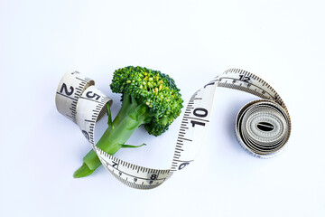 Fresh broccoli isolated on white background whith measuring tape. Healthy lifestyle concept. Diet concept. Weight loss concept. Calorie counting.