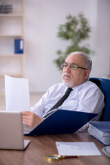 Old male employee working in the office