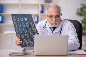 Old male doctor radiologist working in the clinic