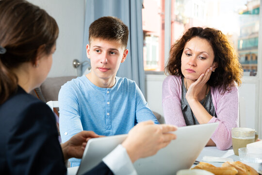 Focused woman and son sitting at home and listening social worker