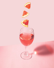 Tasty cocktail on pastel light pink background. Creative drink concept. Minimalistic beverage composition.