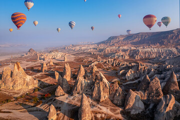 Hot air balloons fly over deep canyons, valleys Cappadocia Goreme National Park with ancient cave...