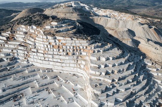 Top view Industry marble quarry and cut white blocks, working yellow tractor, drone aerial