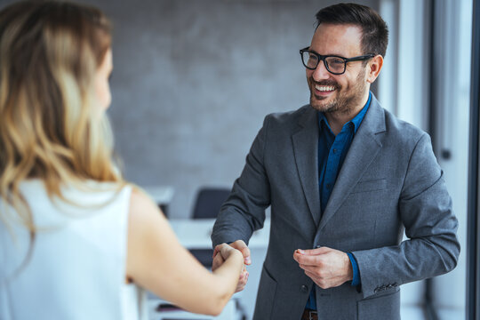 Recruiter shaking successful smiling businesswoman candidate hand at meeting, congratulating with getting new job, manager making great deal with customer, diverse business partners greeting