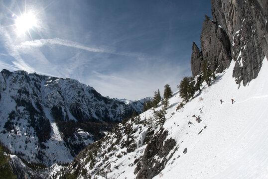 Two young men snowshoeing under blue skies in a mountain vista near Ouray, Colorado.