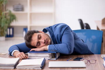 Young male employee unhappy with excessive work in the office