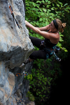 Female American climbing blocky limestone cliff.