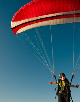 A young woman launching her paraglider in Santa Barbara, CA.