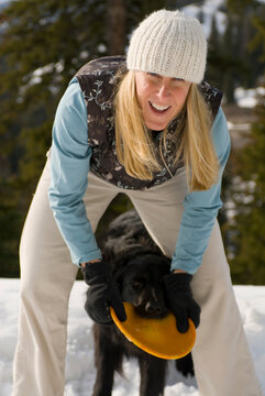 A young woman plays with her dogs in Jackson Hole, Wyoming.