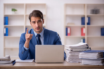 Young male employee and too much work in the office