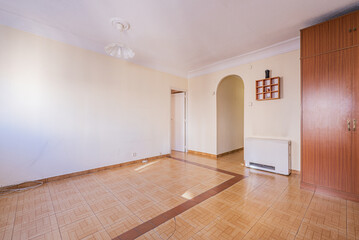 Empty living room with an electric heat accumulator and stoneware floors