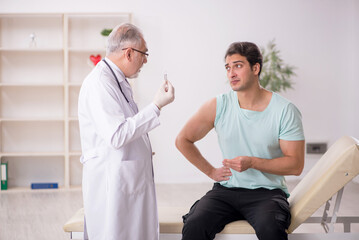 Young male patient visiting old male doctor in vaccination conce