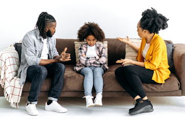 African American parents sort things out with their preschool daughter, yell at her, child resenting parents. Abuse concept, difficulties in the relationship of parents with the child, conflict