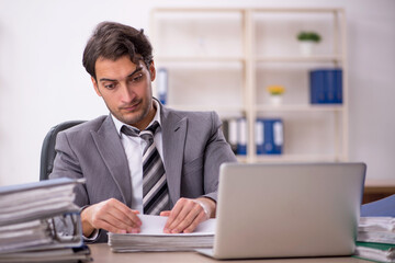 Young male employee unhappy with excessive work in the office