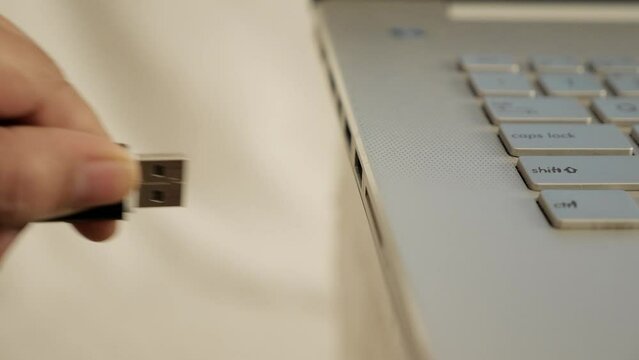 Person pluging out flashdisk from usb port in laptop personal computer, data transfer device concept