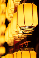 Yellow illuminated Chinese lanterns low angle view at night for the Chinese new year - 566447151