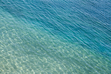Seawater surface, sun glare on water surface, diagonal lines, top view