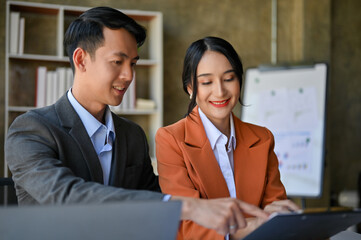 Two professional Asian businesspeople working together in the office
