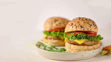 American fast food concept, Tasty beef burgers with fresh vegetables and cheese on ceramic plate