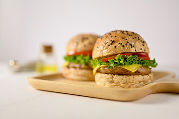 Close-up image of a tasty beef burgers on wooden tray on white background.